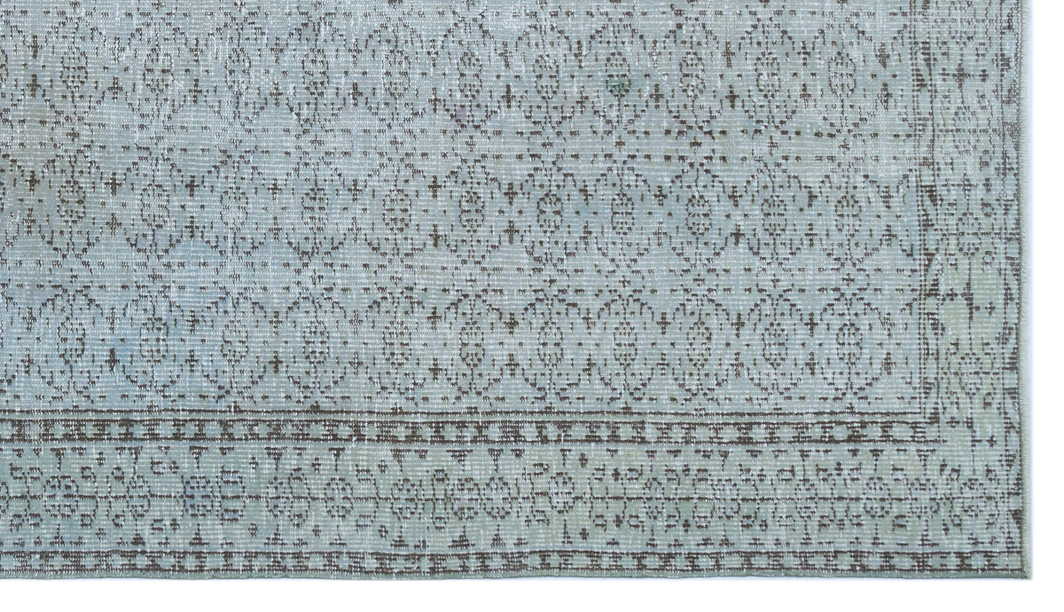 Light blue and brown rug with a distressed traditional medallion pattern and a detailed geometric border.