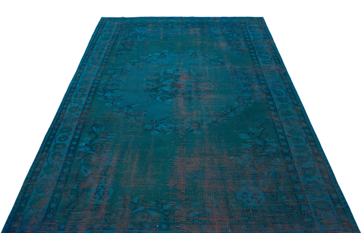 Teal and dark blue distressed rug with a central medallion and traditional border pattern on a white background.