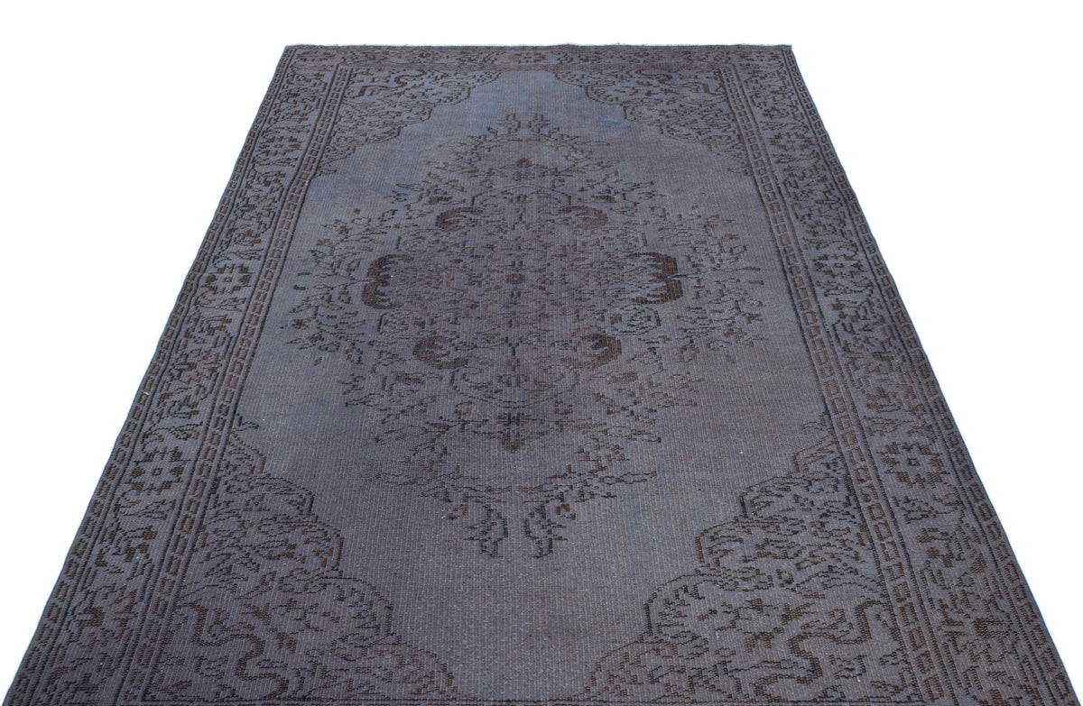 Charcoal grey vintage-style rug with a central floral medallion and ornate border pattern on a white background.