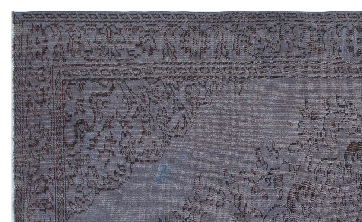 Dark charcoal rug with a tonal, intricate floral medallion pattern and a detailed border.