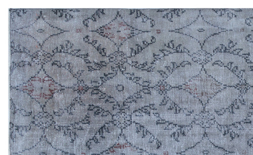 Load image 1 in gallery view. Grey and charcoal distressed rug with a repeating geometric medallion pattern and subtle red accents.