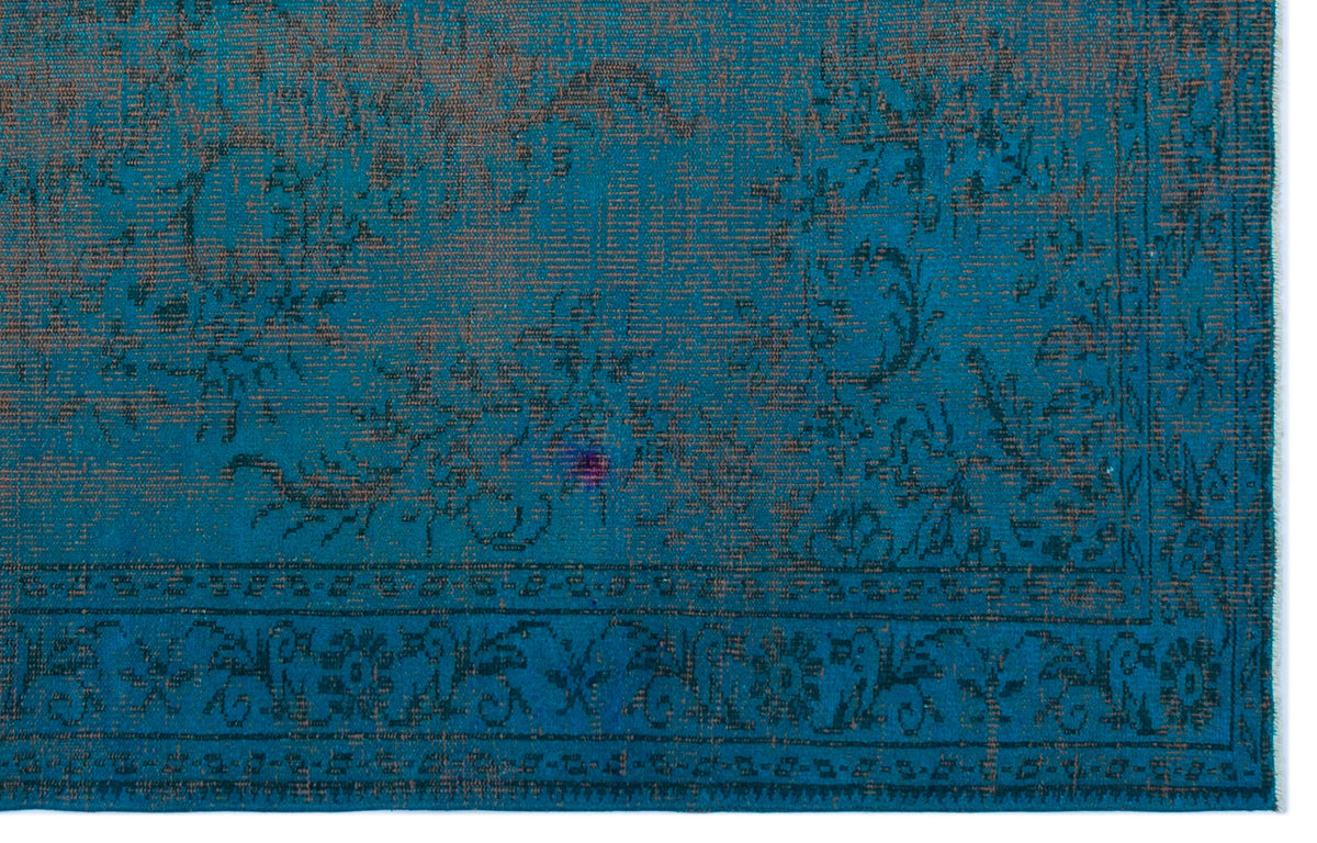 Teal and brown distressed rug with a traditional floral medallion pattern and a detailed border.