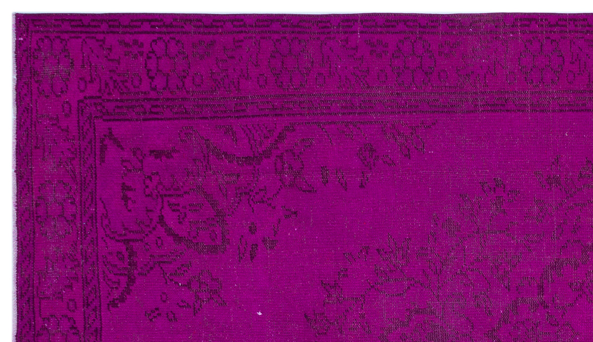 Magenta rug with a dark purple traditional floral medallion border and intricate botanical pattern.