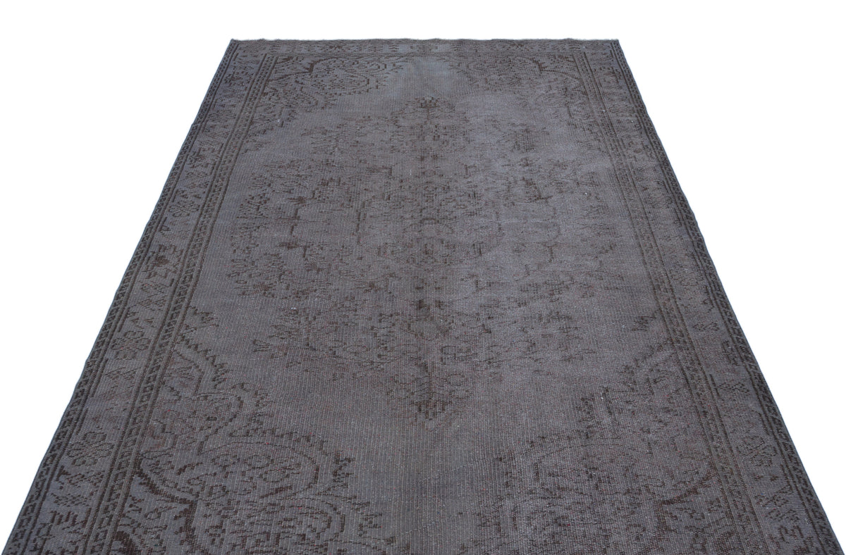 Charcoal grey vintage-style rug with a faded traditional medallion pattern and ornate border on a white background.