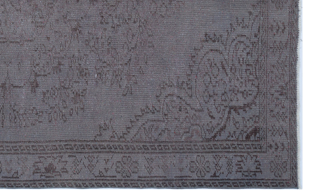 Charcoal grey rug with a subtle, tonal traditional floral medallion pattern and a detailed geometric border.