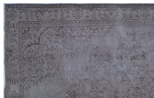 Load image 1 in gallery view. Charcoal grey rug with a faded, traditional floral medallion pattern and a detailed geometric border.