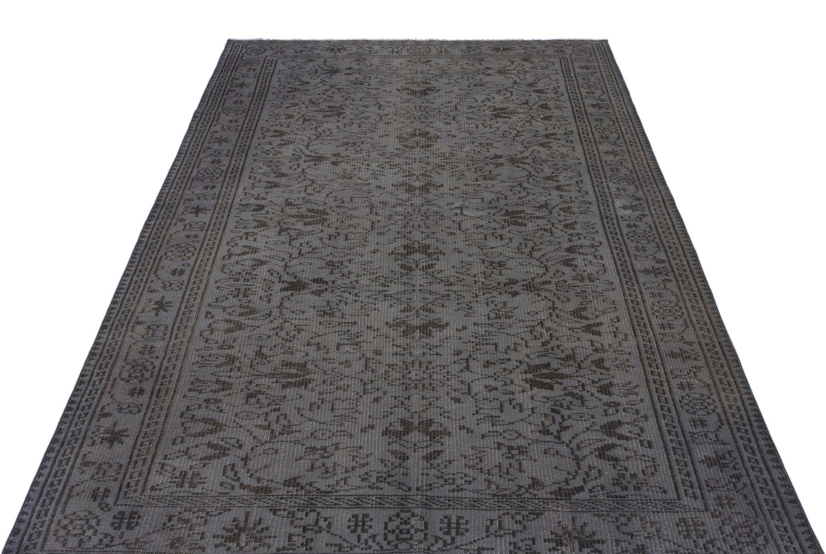 Charcoal grey traditional rug with a distressed floral medallion pattern and a detailed geometric border.