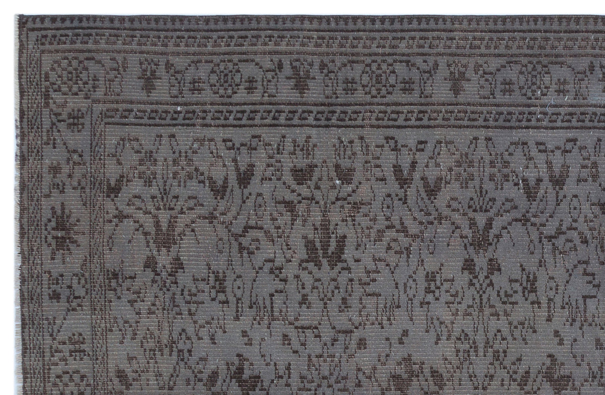 Dark gray and brown rug with a traditional floral medallion border and intricate botanical pattern.