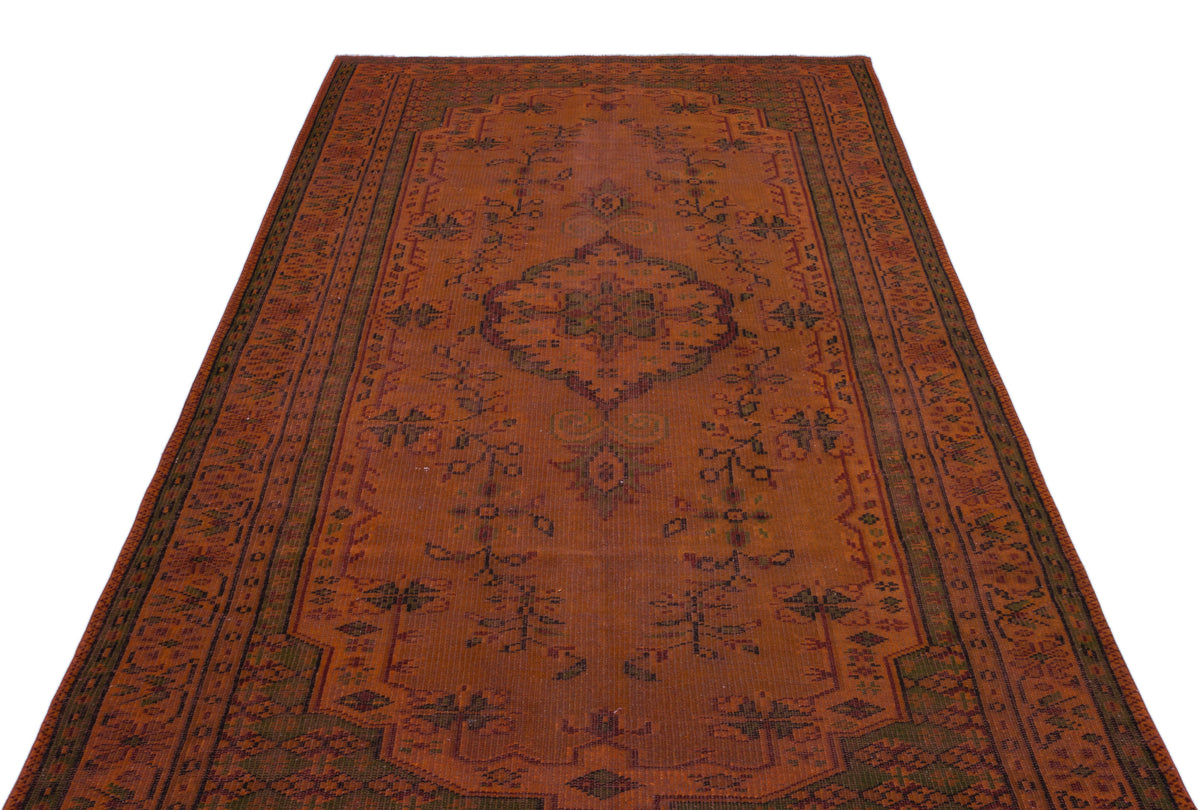 Rust-colored traditional rug with a central medallion and intricate floral border patterns on a white background.