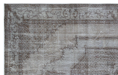 Load image 1 in gallery view. Distressed taupe and brown vintage-style rug with a faded traditional border and geometric medallion corner detail.