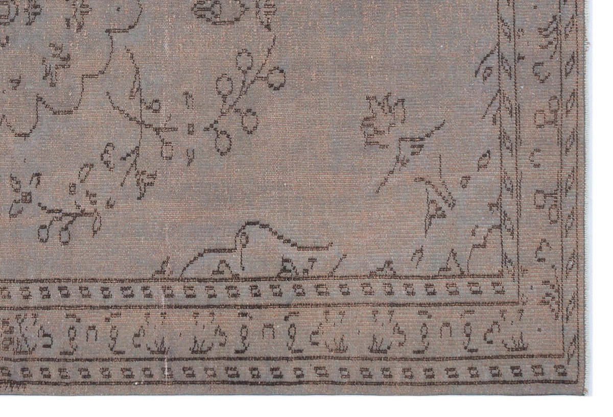 Taupe rug with a dark brown linear floral and geometric border pattern on a white background.