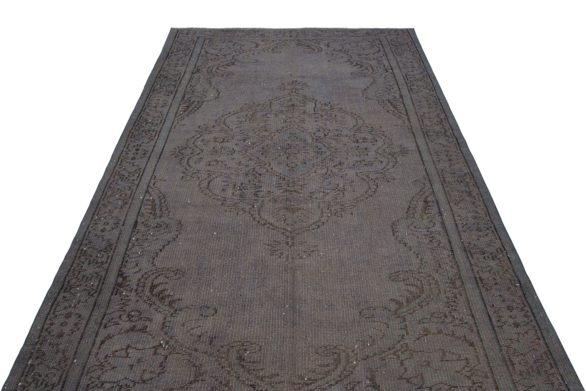 Dark charcoal distressed rug with a traditional central medallion and ornate border pattern on a white background.