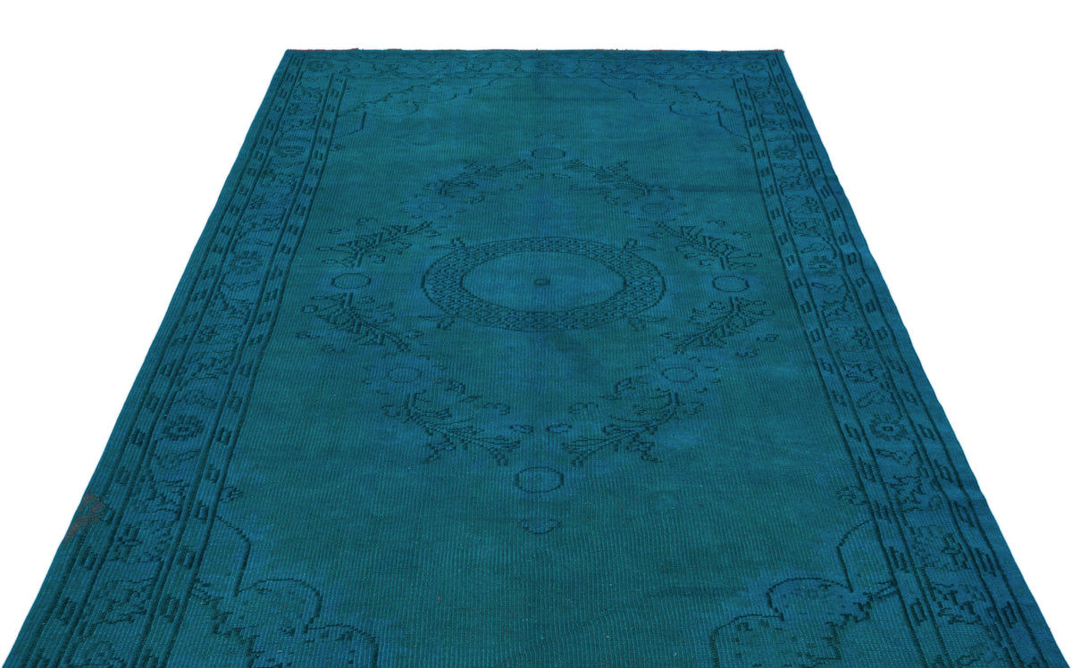 Teal monochromatic rug with a central medallion and traditional border pattern on a white background.