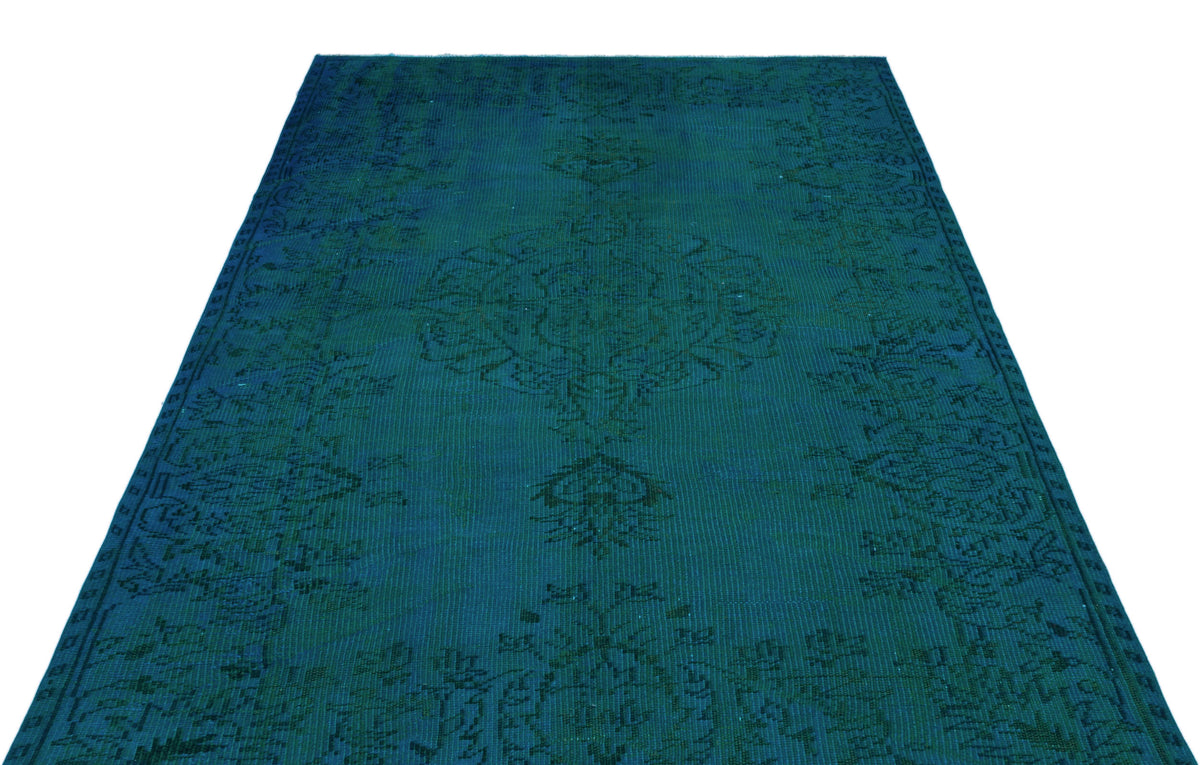 Deep teal vintage-style rug with a dark, tonal floral medallion pattern on a white background.