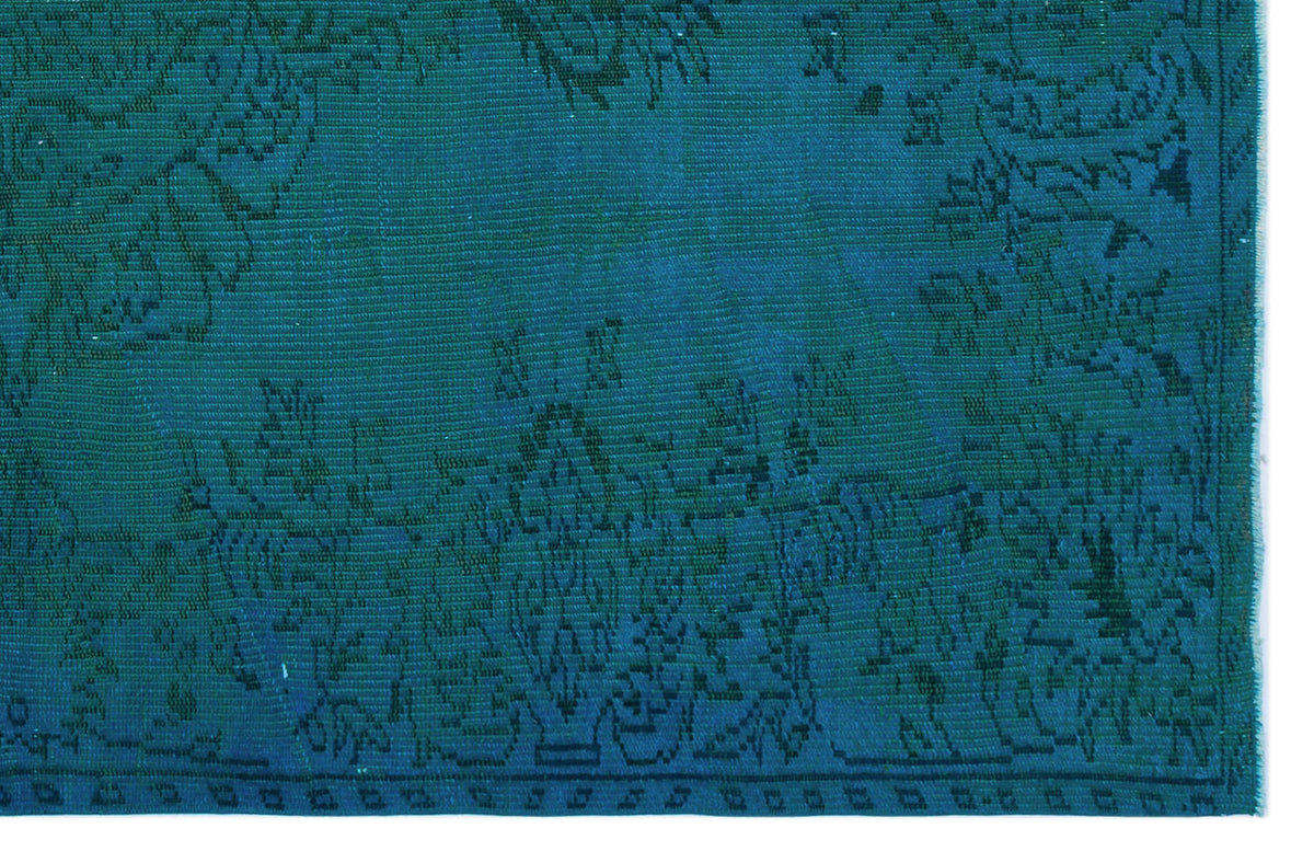Teal rug with a dark blue traditional floral medallion pattern and a geometric border.