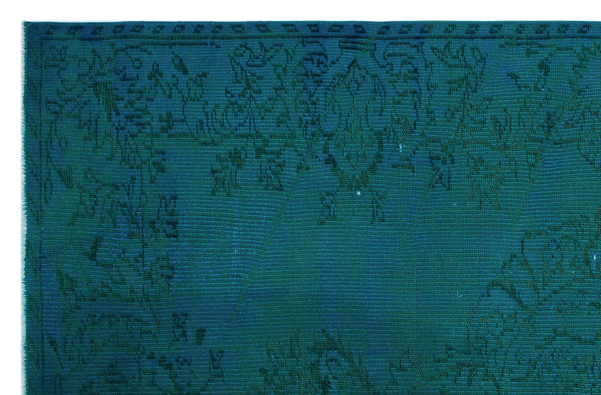 Teal monochromatic rug with a subtle, distressed traditional floral medallion pattern.