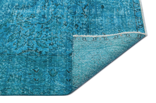 Load image 1 in gallery view. Bright turquoise distressed rug with a faded traditional floral pattern and a folded corner showing the woven backing.