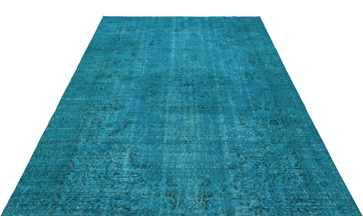 Teal distressed vintage-style rug with a faded central medallion and ornate border pattern on a white background.