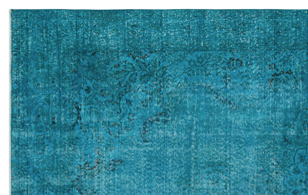Teal distressed rug with a faded traditional floral medallion pattern.