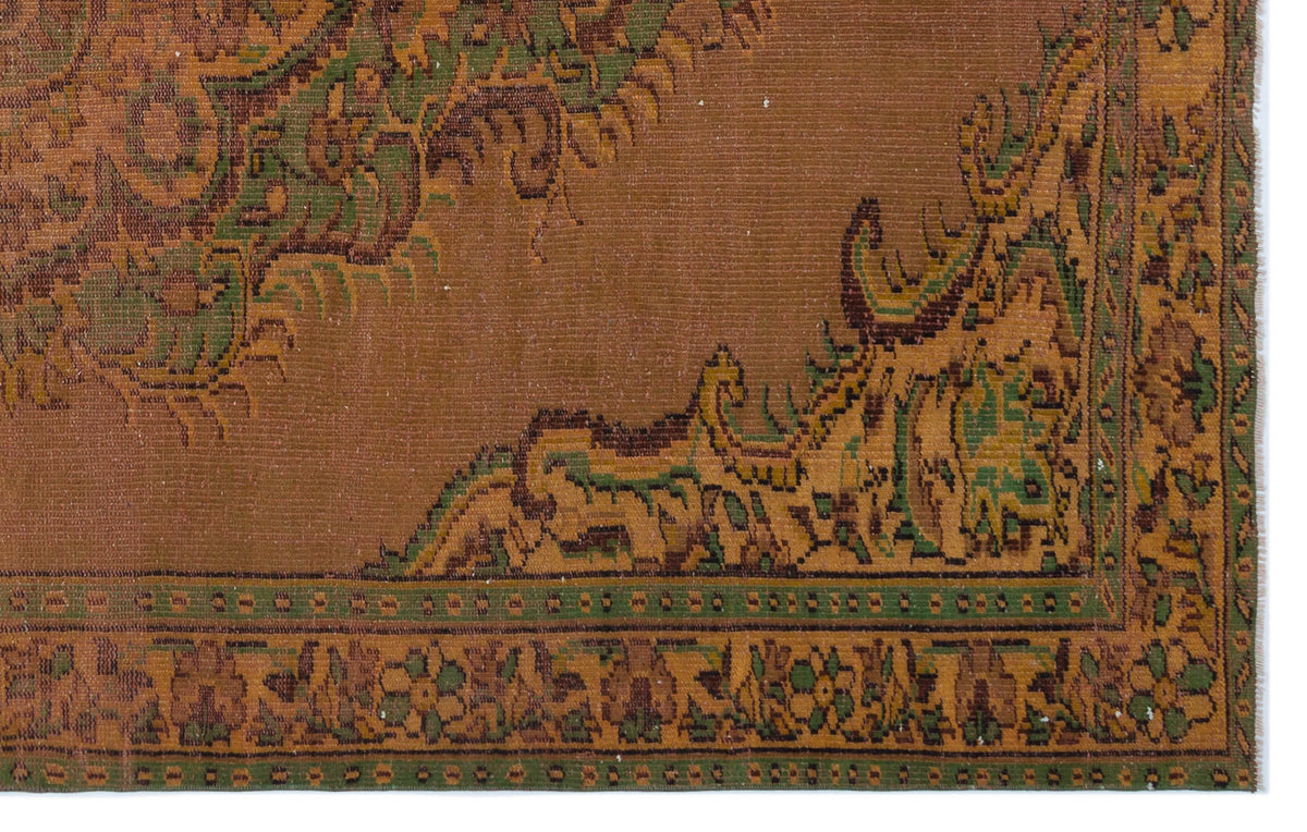 Brown, green, and gold traditional rug with an ornate floral border and central medallion detail.
