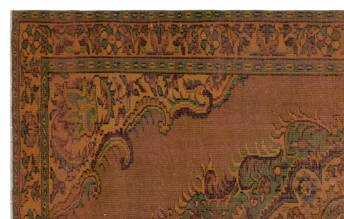 Rust-colored traditional rug with a dark green and brown ornate floral border and corner medallion detail.