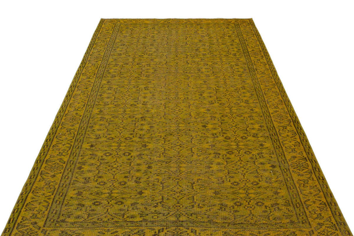 Mustard yellow rug with a dark brown traditional floral medallion pattern and a detailed border on a white background.