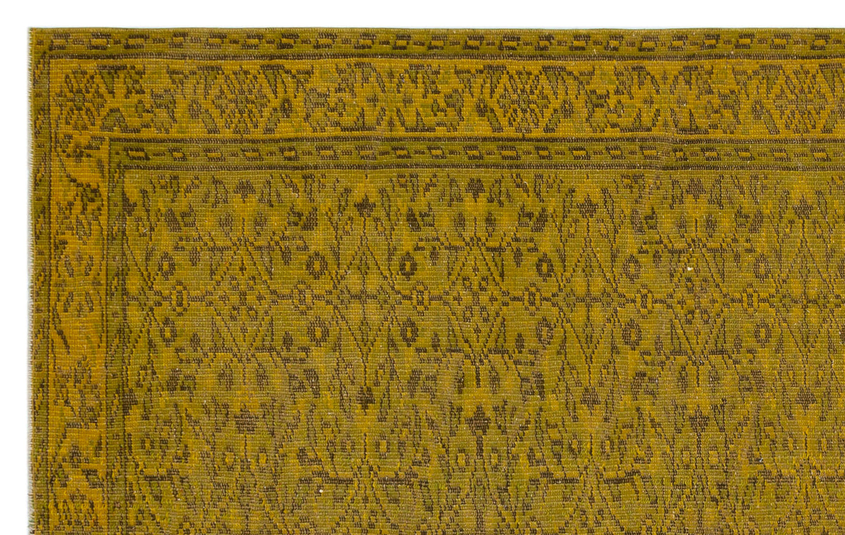 Mustard yellow rug with a dark olive traditional floral and geometric border and center pattern.