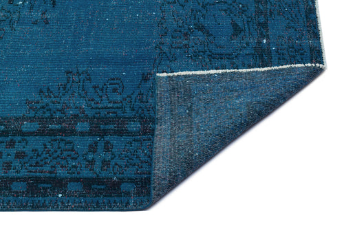 Load image 1 in gallery view. Deep blue distressed rug with a dark geometric border pattern, shown with a folded corner on a white background.