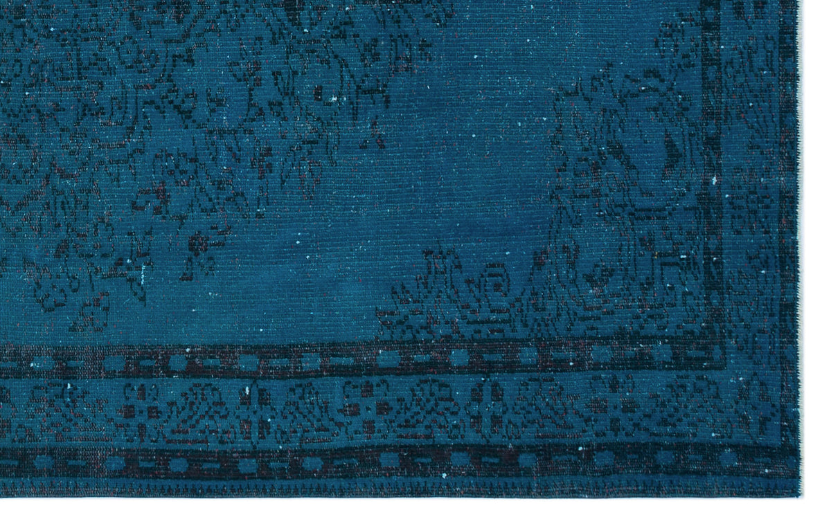 Deep teal rug with a black distressed traditional medallion pattern and a geometric border.