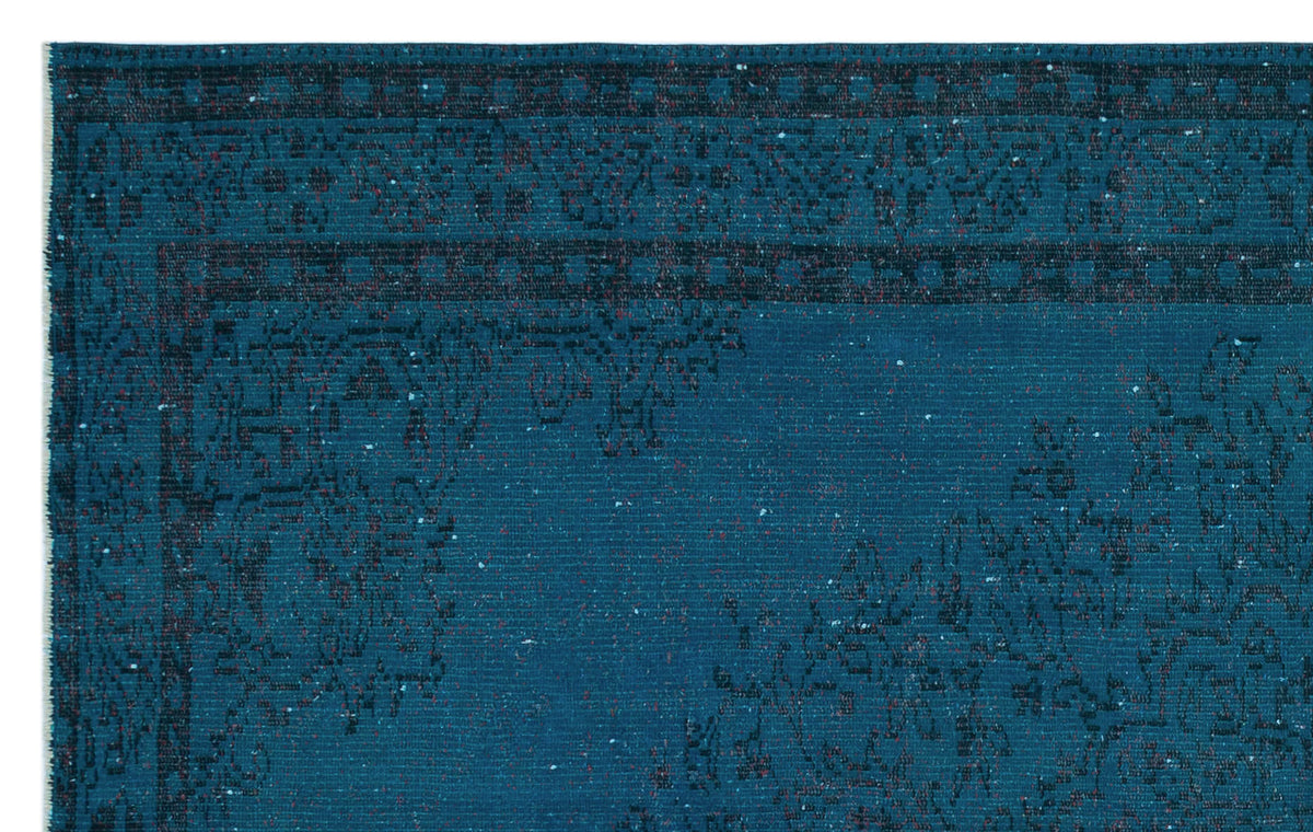 Teal rug with a dark, distressed traditional floral medallion pattern and a geometric border.