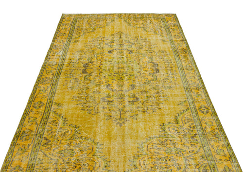 Load image 1 in gallery view. Mustard yellow vintage-style rug with a distressed central medallion and ornate border pattern on a white background.