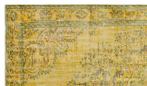 Load image 1 in gallery view. Mustard yellow and olive green distressed rug with a traditional floral medallion border and faded central pattern.