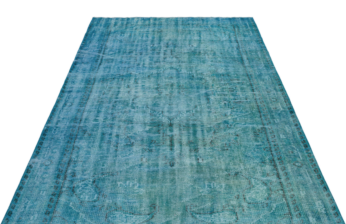 Teal distressed area rug with a faded traditional medallion pattern on a white background.