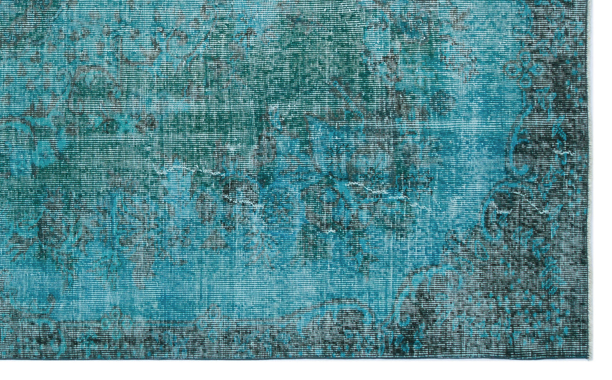 Teal and black distressed rug with a faded traditional medallion pattern.