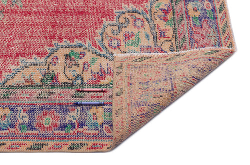 Load image 1 in gallery view. Red and blue distressed vintage-style rug with a floral medallion pattern, shown folded to reveal the tan backing.