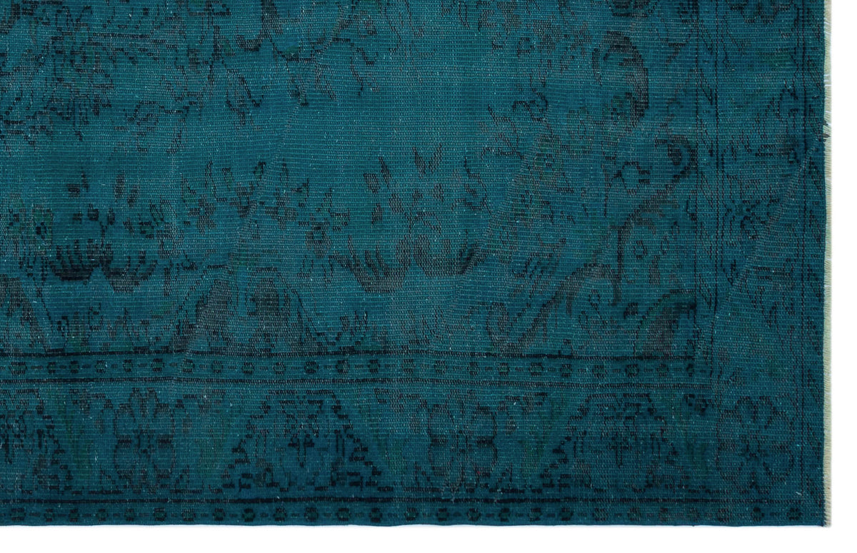 Teal rug with a dark, distressed traditional floral medallion pattern and a bordered edge.