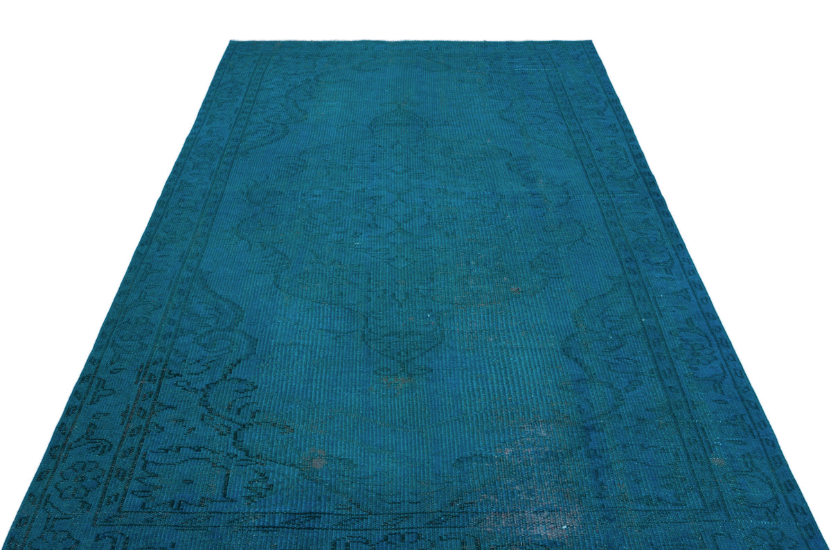 Monochromatic teal vintage-style rug with a faint, distressed traditional medallion pattern on a white background.