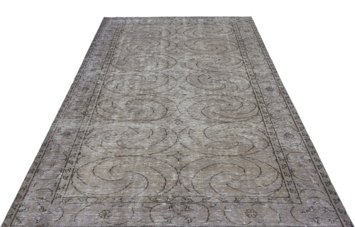 Load image 1 in gallery view. Taupe and grey distressed vintage rug with a repeating spiral medallion pattern and a decorative border.