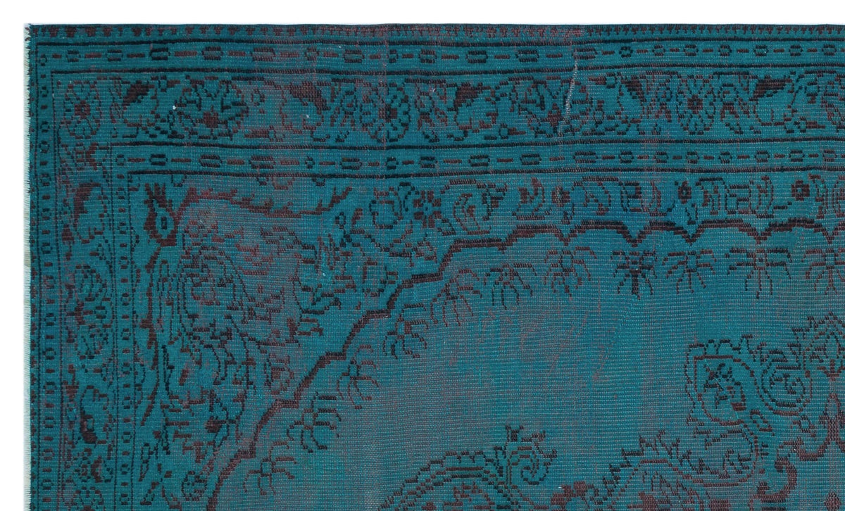 Teal and dark brown traditional rug with an intricate floral medallion border and distressed finish.