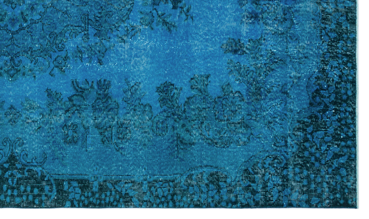 Bright blue distressed rug with a dark navy floral medallion pattern and ornate border.