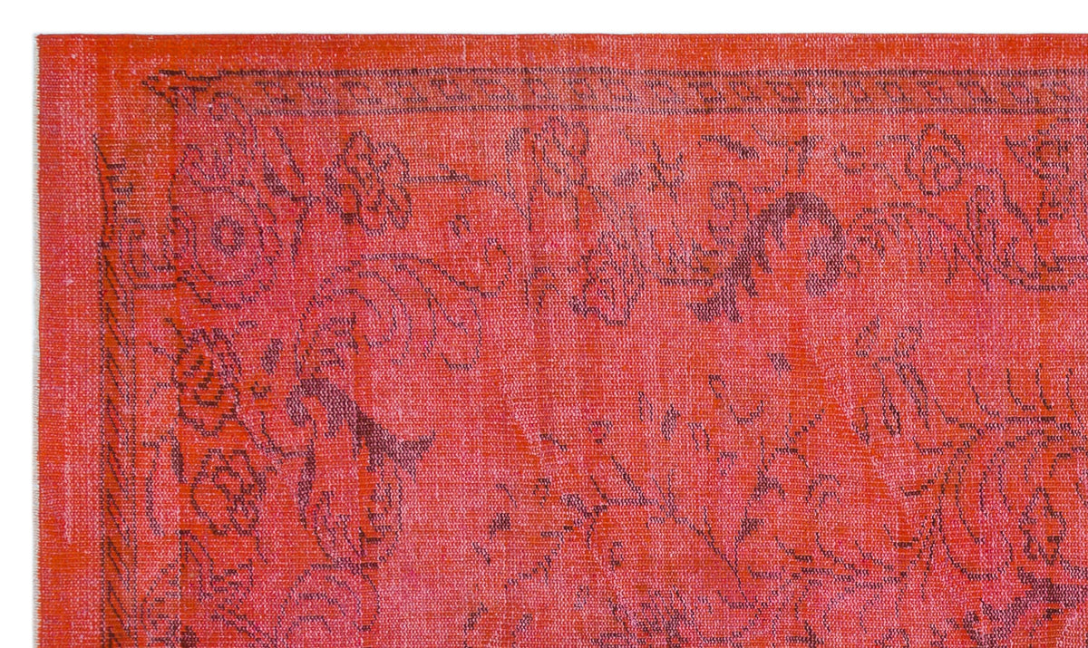 Vibrant red rug with a distressed, dark charcoal floral medallion pattern and a geometric border.