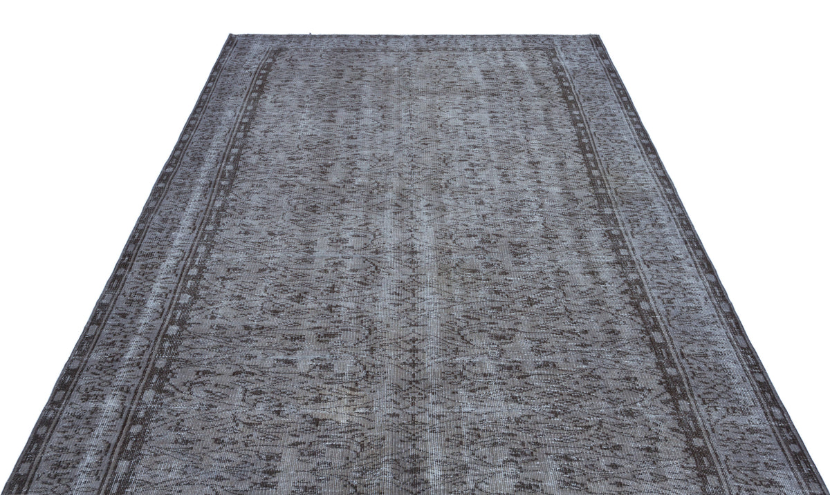 Charcoal and grey distressed vintage-style rug with a faded floral medallion pattern and a bordered edge.