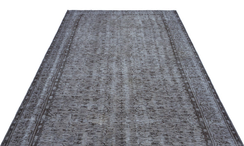 Load image 1 in gallery view. Charcoal and grey distressed vintage-style rug with a faded floral medallion pattern and a bordered edge.
