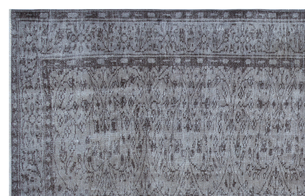 Grey and charcoal distressed rug with a traditional floral medallion pattern and a decorative border.