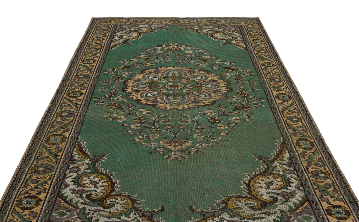 Emerald green traditional rug with a central floral medallion and ornate border, isolated on a white background.