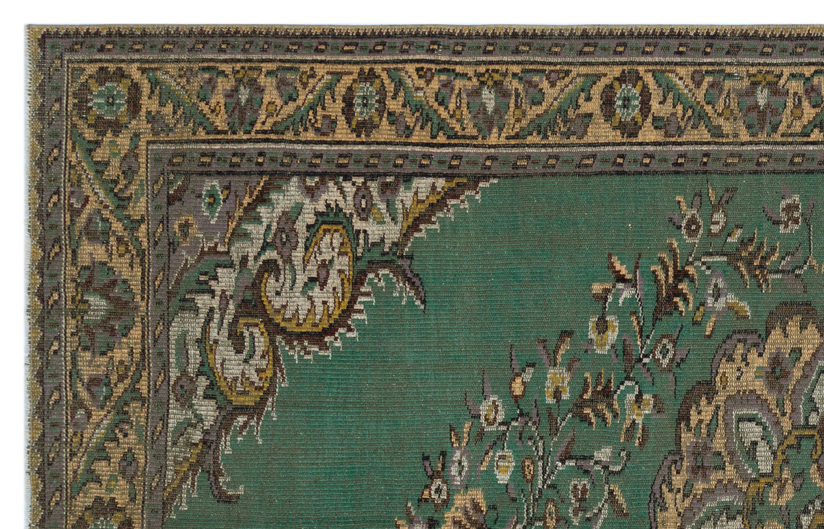 Emerald green traditional rug with a decorative border and intricate floral medallion pattern in gold, grey, and brown.