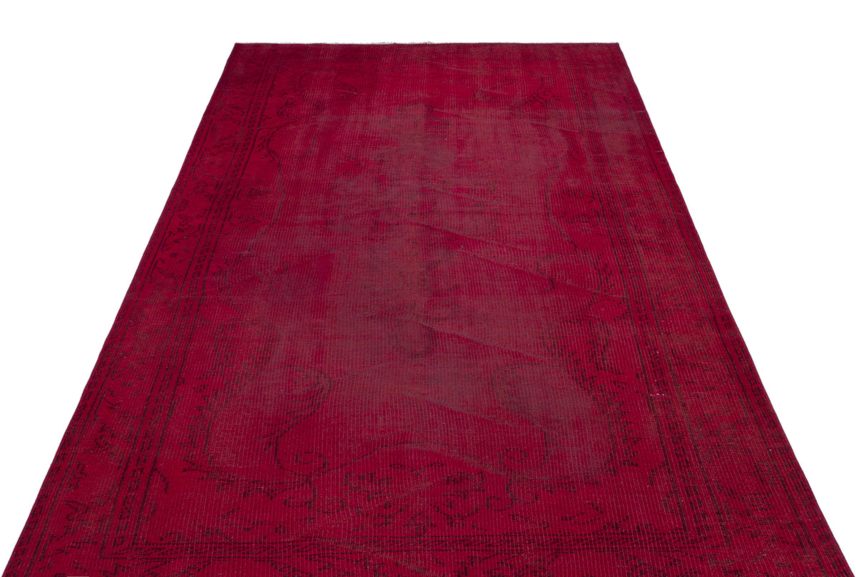 Deep red vintage-style rug with a faded, dark floral medallion pattern and a decorative border on a white background.
