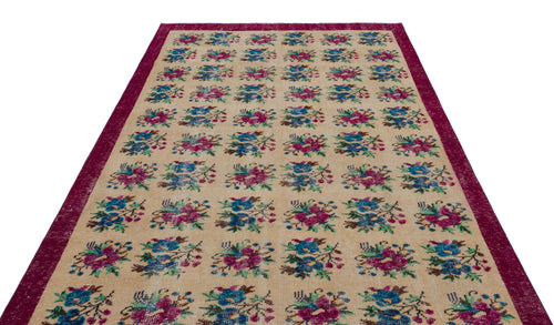 Load image 1 in gallery view. Beige rug with a repeating floral pattern in magenta, blue, and green, framed by a wide magenta border.