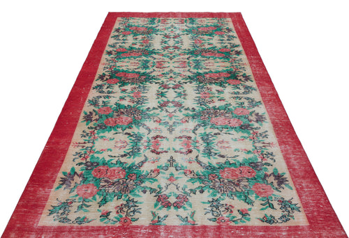Load image 1 in gallery view. Distressed beige rug with a red border and a repeating floral pattern in shades of red, green, and dark grey.