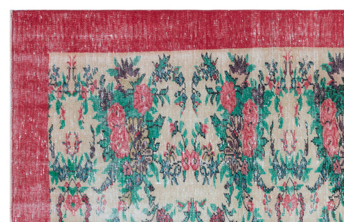 Load image 1 in gallery view. Distressed beige rug with a red border and a multi-colored floral pattern in red, green, and dark blue.